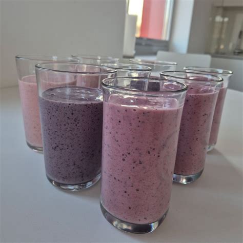 Zbirka različnih zdravih smoothijev v kozarcih, nekateri okrašeni s svežim sadjem