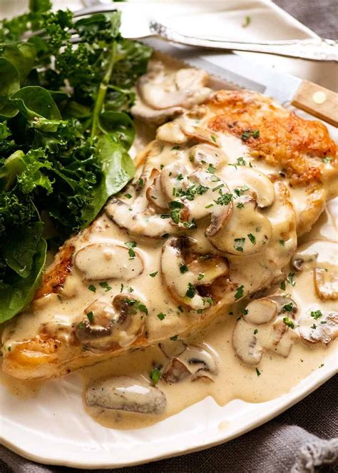 Thematic photo of chicken breast with mushroom sauce on a plate, garnished.