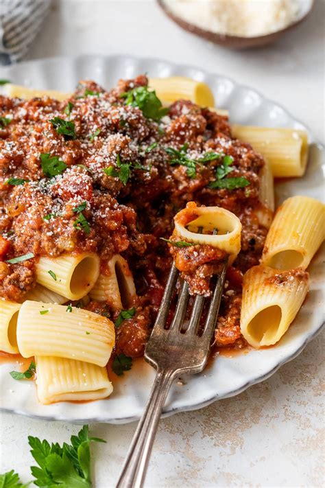 fotografija veganske bolognese omake s testeninami, posute s svežimi zelišči