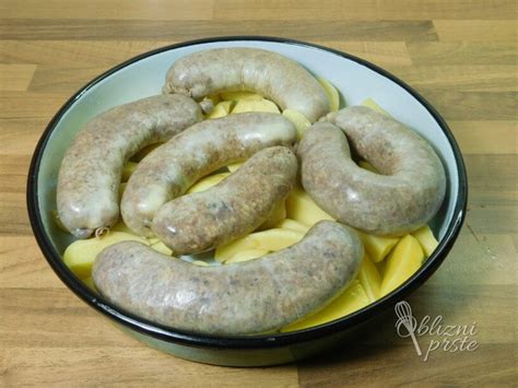 Fotografija bogate gobove enolončnice s krompirjem, postrežene v rustikalnem krožniku s svežim peteršiljem.