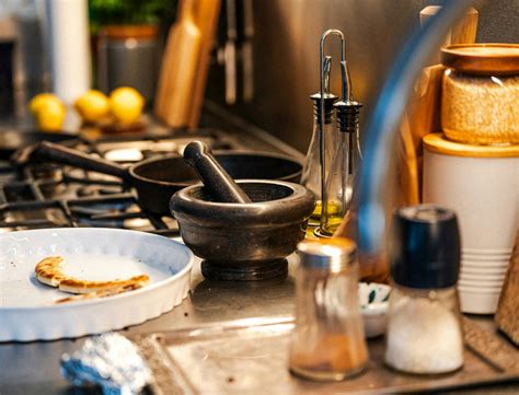 Thematic photo of an electric pan in use on a balcony or kitchen counter, cooking various foods.