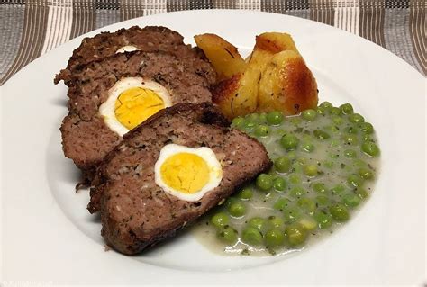 Thematic photo of a Stefani pečenka, beautifully sliced to show hard-boiled eggs inside, served with sauce and side dishes.