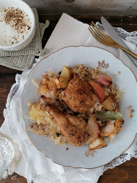 Pekač z zapečenim piščancem, kislim zeljem, krompirjem in jabolčnimi krhlji.