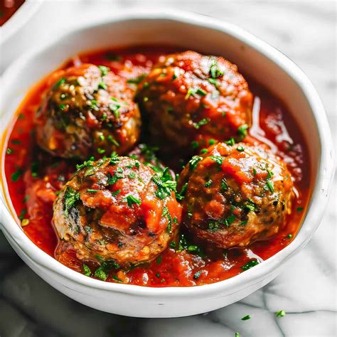 Thematic photo of cheese-stuffed meatballs in a tomato sauce, garnished with fresh basil.