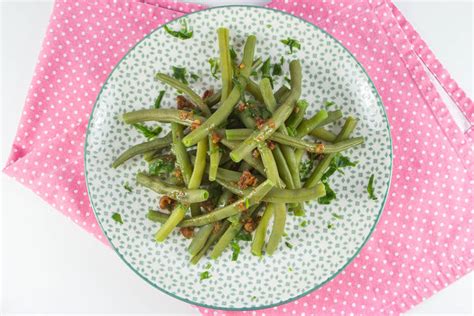 Različne pripravljene jedi iz stročjega fižola, ki prikazujejo njegovo vsestranskost.