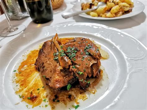 Fotografija: Postrežen krožnik z rezino polnjene telečje krače in domačo omako