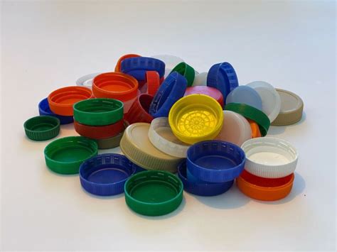 Prikaz različnih materialov za izdelavo domačih igrač: les, papir, plastični zamaški in naravni materiali.