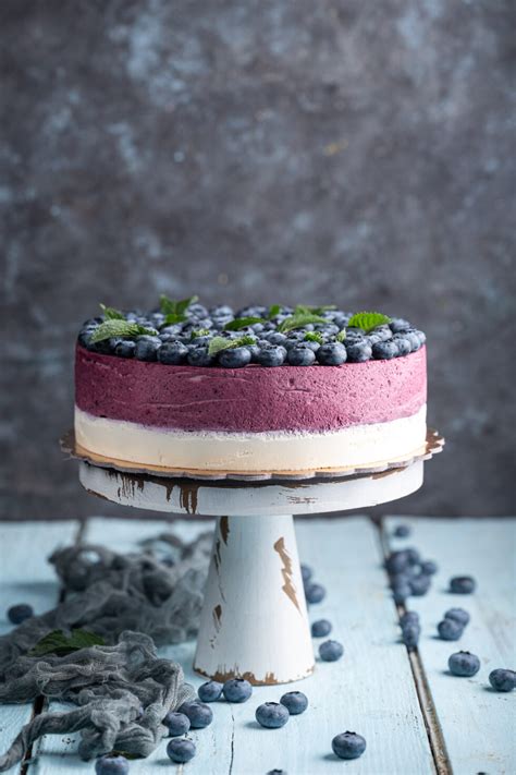 Tematska fotografija borovničeve veganske torte, okrašene z borovnicami in limetino lupinico