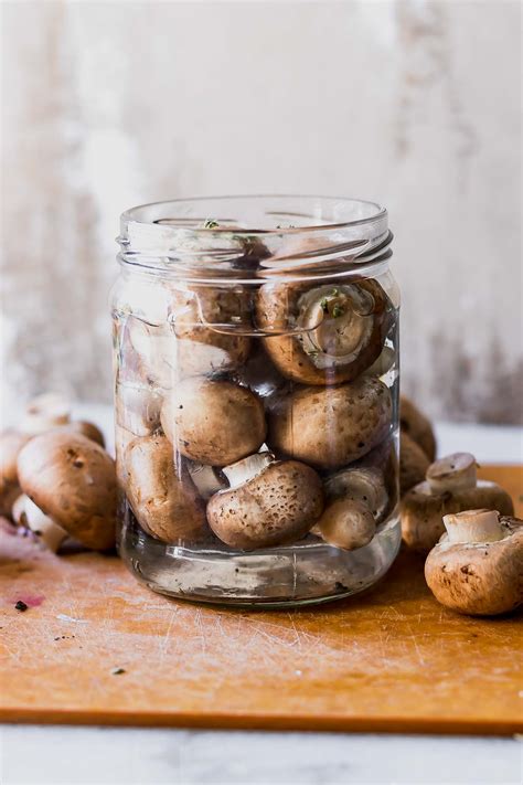 The image should depict jars of pickled mushrooms, clearly labeled and sealed.