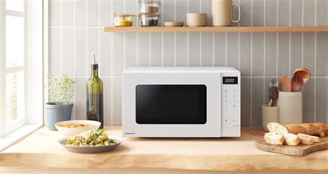 Shematski prikaz delovanja mikrovalovne pečice z magnetronom in širjenjem mikrovalov v prostoru za kuhanje.