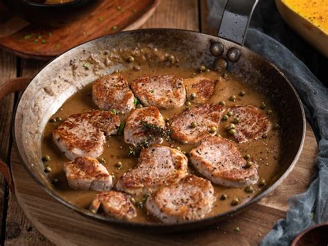 različni začinjeni svinjski medaljoni v ponvi, pripravljeni za peko