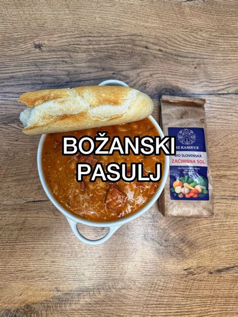 Tematska fotografija, ki prikazuje pasulj v krožniku z rezinami svežega kruha in surovo čebulo ob strani