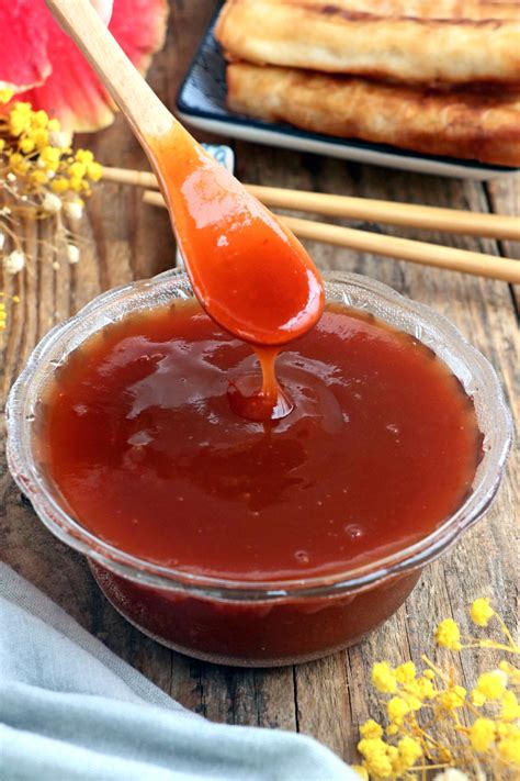 The process of making sweet and sour sauce in a pot on the stove, showing the ingredients mixing and thickening.