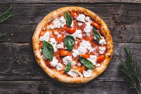 Fotografija različnih jedi in pizz iz menija Halo Pizza, vključno s pizzo Margherita D.O.P. in predjedmi.