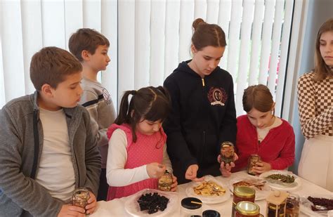 Otroci skupaj z odraslimi polnijo modelčke za mafine