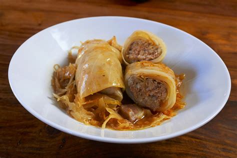 Fotografija postrežene sarme s pire krompirjem.