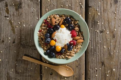 Ilustracija ovsenih kosmičev s sadjem in oreščki, ki ponazarja zdrav zajtrk.