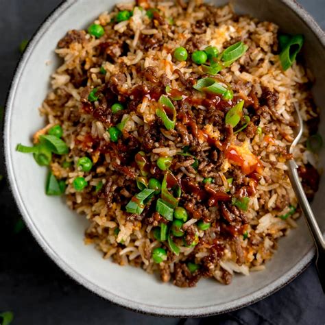 The process of mixing ingredients for stuffing, with minced meat, rice, and herbs in a bowl