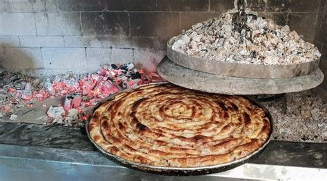 Fotografija sveže pečenega mesnega bureka izpod sača