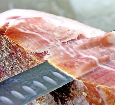 Fotografija rezin kuhanega pršuta, elegantno položenih na pizzo