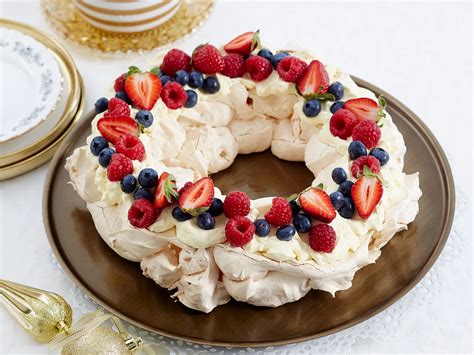Sladka miza s pestrim izborom prazničnih sladic, vključno s potico in Pavlova torto.