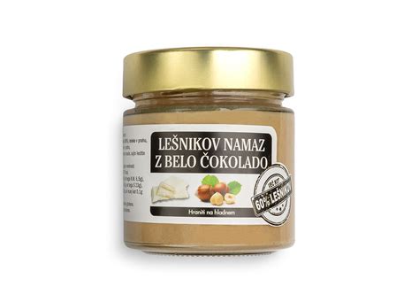 Domači lešnikov namaz v kozarcu z lešniki in čokolado v ozadju