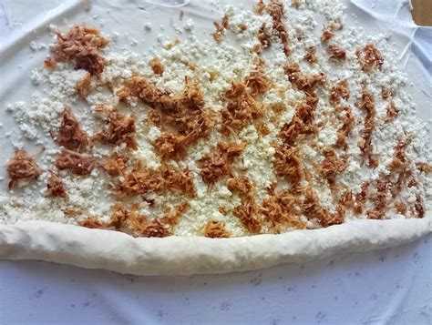 Ilustracija postopka priprave skutne pite z vlečenim testom, prikazuje plastenje testa in nadeva.