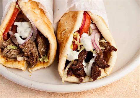 Prikaz priprave mesa na navpičnem vrtljivem nabodalu, značilnem za gyros