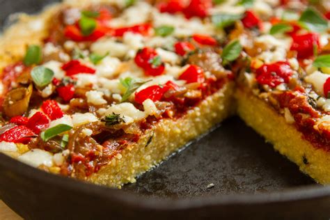 A colorful assortment of chopped vegetables on a polenta pizza base