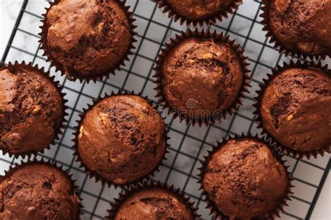 Thematic photo of freshly baked chocolate muffins on a cooling rack.