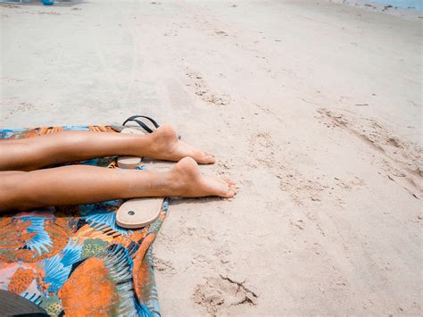 Tematska fotografija: ženska nanosi marmelado za sončenje na plaži