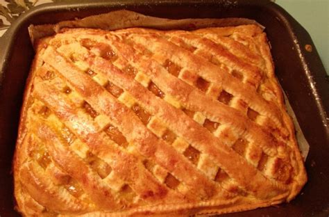 Pripravljena pita v pekaču, pred peko, s prebodenim zgornjim testom.