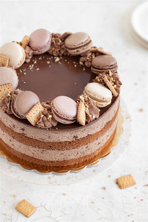 Fotografija servirane čokoladne torte, okrašene s piškoti in čokolado