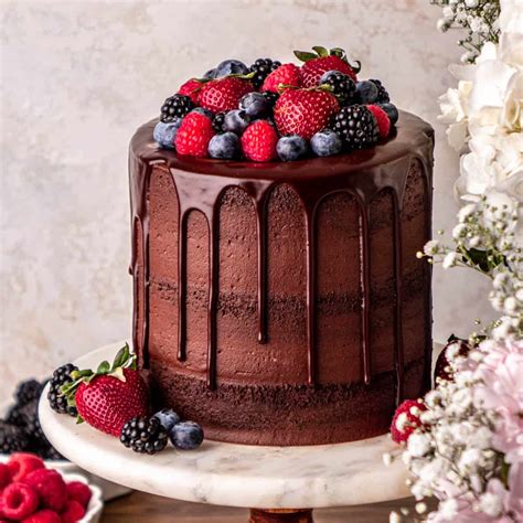 Thematic photo of a delicious looking raw chocolate cake decorated with fruits and nuts