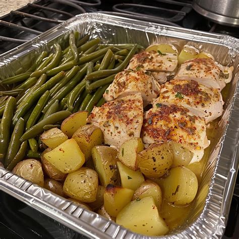 Photo of baked chicken and potatoes with herbs in a foil package