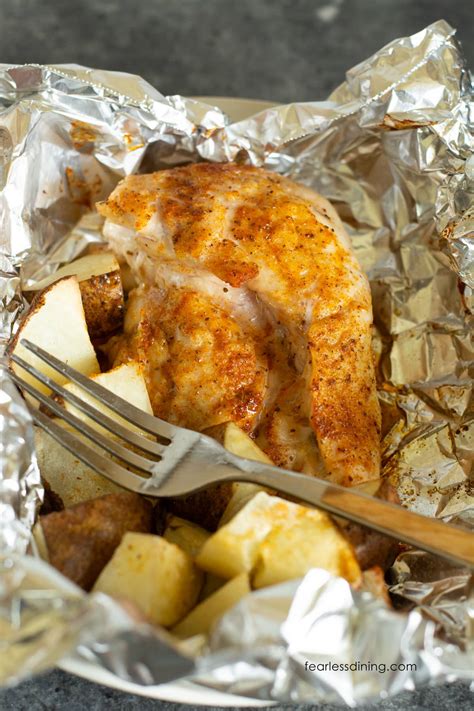 Close-up photo of juicy chicken breast baked in foil with steam rising