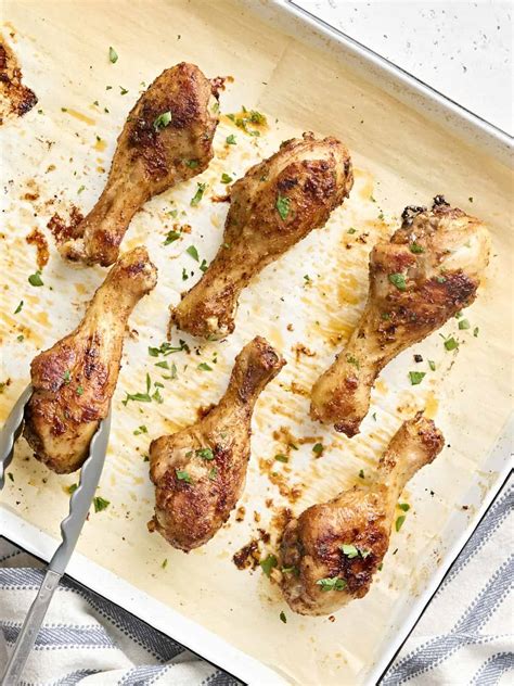 Photo of individually wrapped chicken drumsticks in foil with herbs, ready to serve