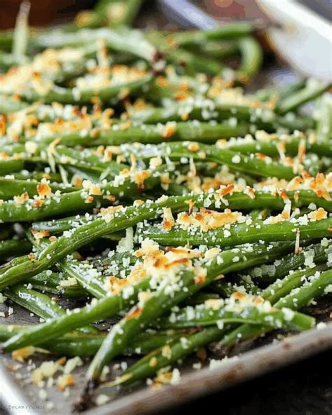 Thematic photo of green beans with parmesan cheese on a baking tray, ready for the oven
