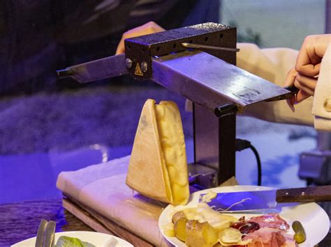 Ilustracija tradicionalne švicarske jedi raclette s sirom, krompirjem in kumaricami