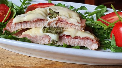 Fotografija: Telečji zrezki Saltimbocca na posteljici iz rukole in paradižnika