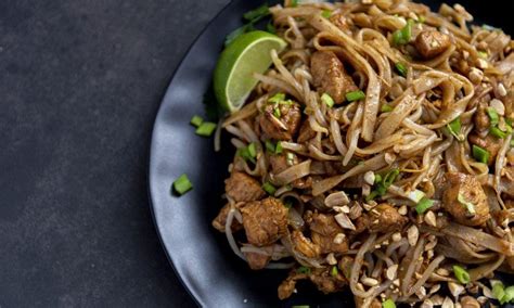 Končana jed Piščančji Pad Thai, pripravljena za postrežbo z limeto in koriandrom