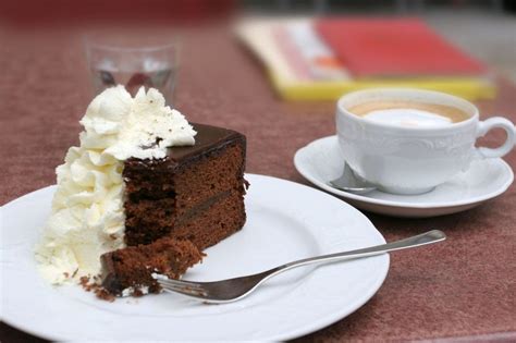 Fotografija končne Sacher torte z rozeto stepene smetane ob strani
