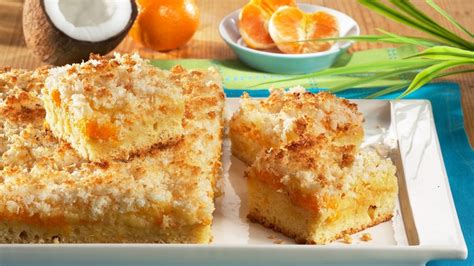 Fotografija pripravljenega sočnega peciva z mandarinami, okusno narezano na kose.