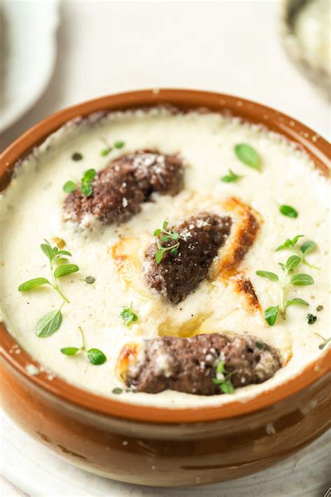 postrežen krožnik čevapčičev s somunom, kajmakom in čebulo