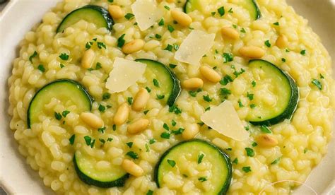 Fotografija sveže pripravljene kremaste rižote z bučkami, okrašene s svežo baziliko in parmezanom.