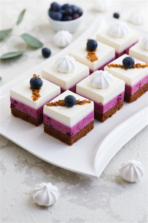 Limonin kolač z grškim jogurtom in svežimi borovnicami, pripravljen za postrežbo.