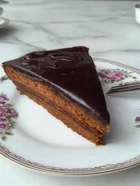 Sacher torta z rezi, ki razkrivajo različne sadne prelive
