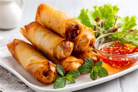 Thematic photo of golden crispy spring rolls with dipping sauce