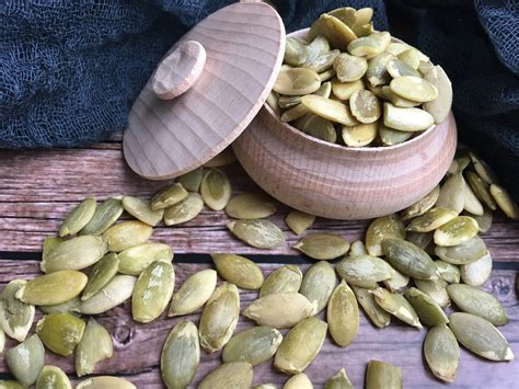 Prikaz bučnih semen, orehov in bučnega olja kot okrasa za juho