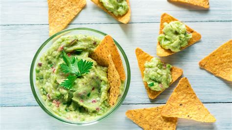Fotografija servirane omake guacamole s tortilja čipsom in svežimi sestavinami